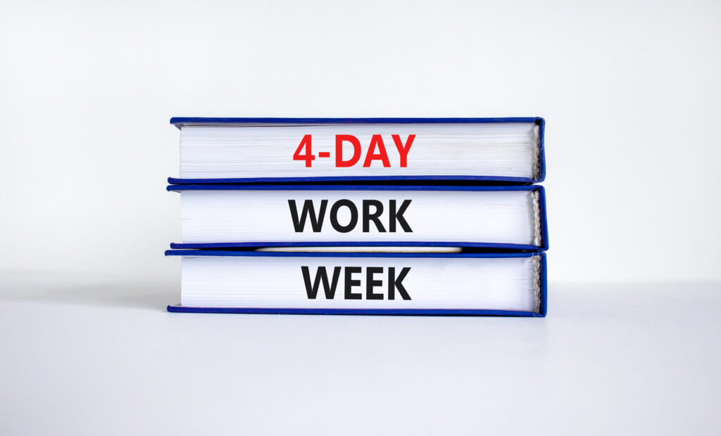 Three text books stacked on top of each other. In the binding on each book is the word 4-Day, Work, Week.