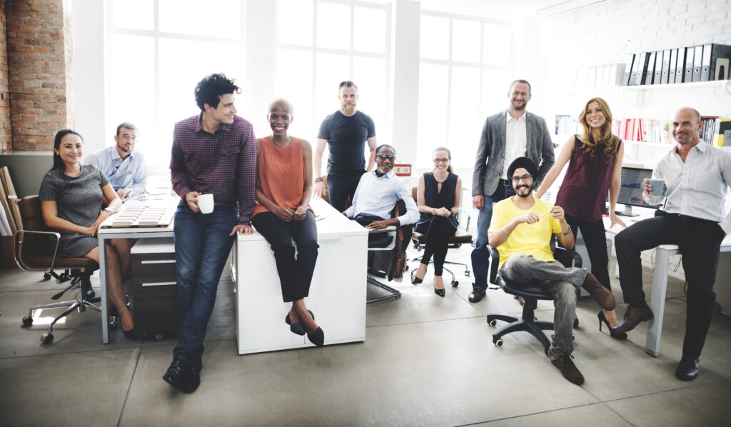 Diverse business team smiling; embrace DE&I as a catalyst